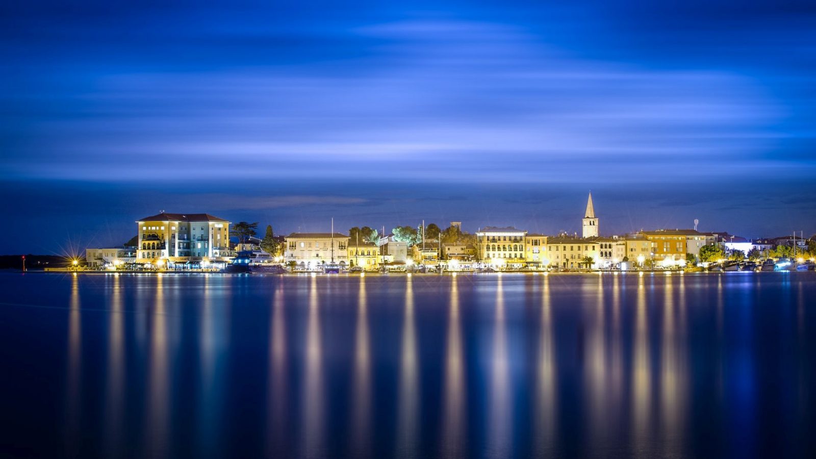 Night view of Poreč Old Town and waterfront with reflections on the Adriatic Sea