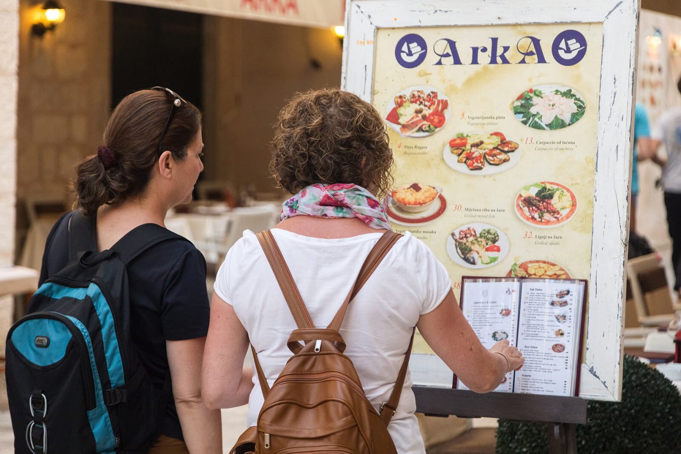 Tourists checking restaurant prices in Dubrovnik, Croatia - 2025 travel costs and dining budget tips