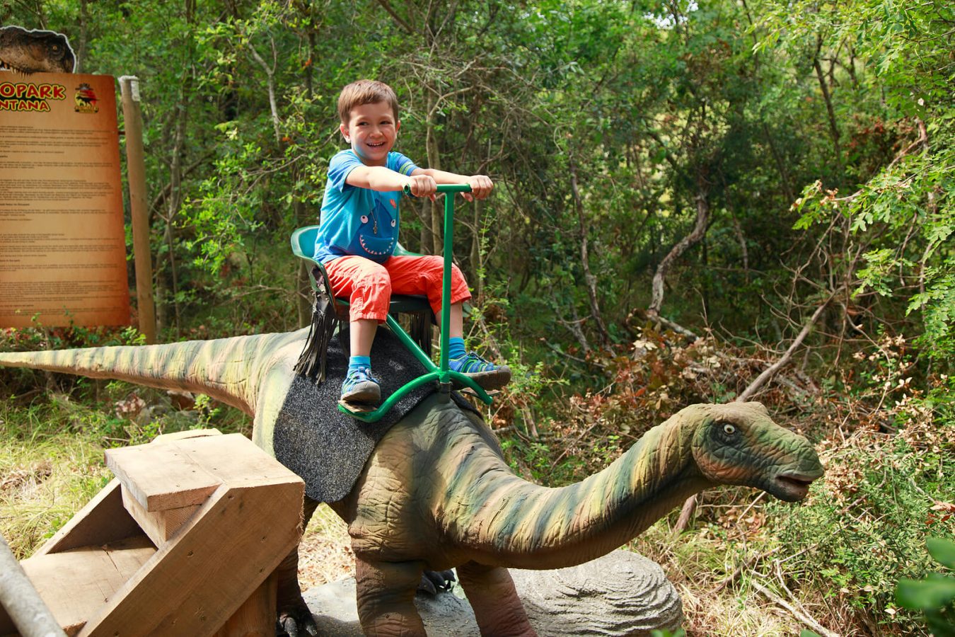a child riding a dinosaur at the Dino Park Funtana